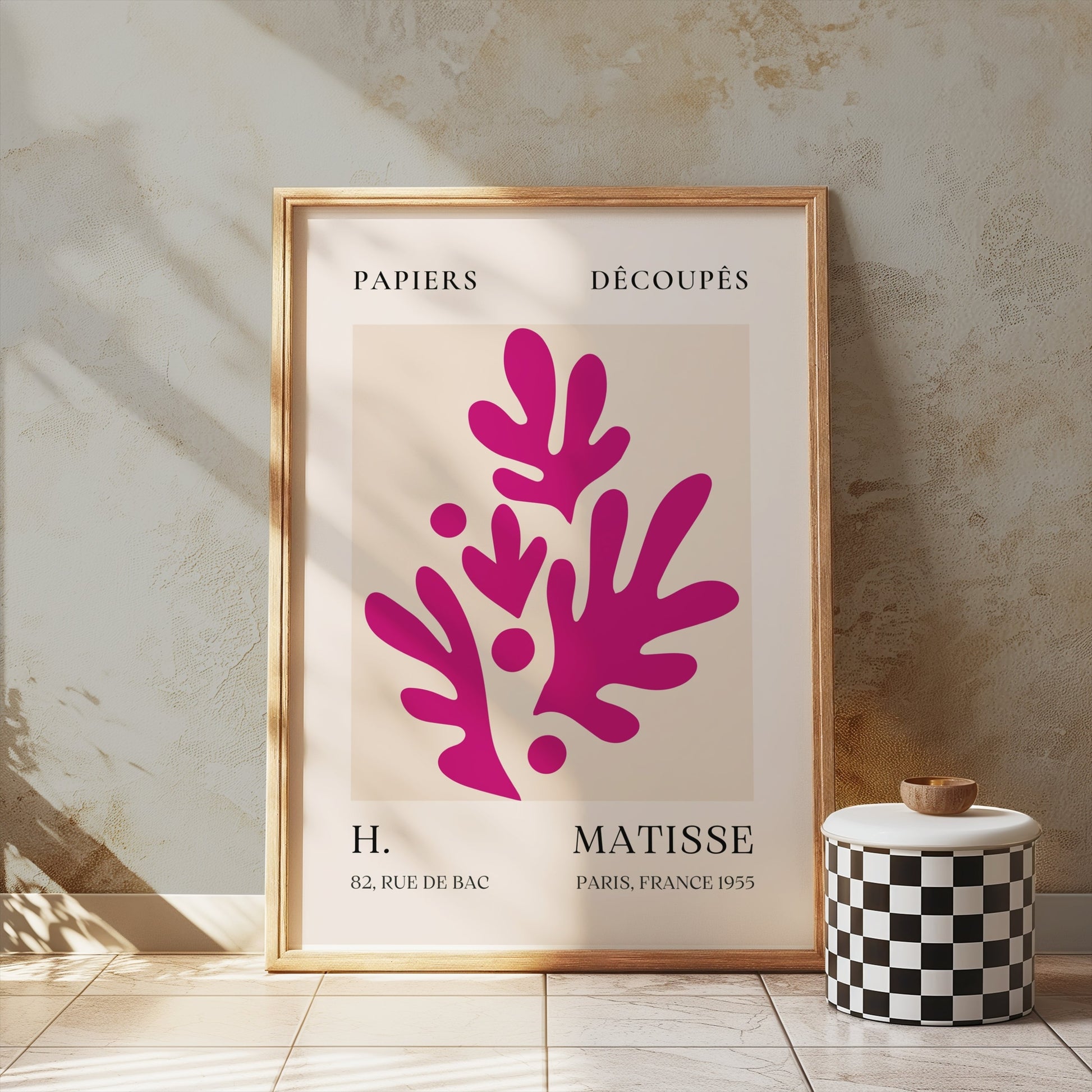 Henri Matisse Paris France 1955 Papiers Découpés poster in a wooden frame leaning against a textured wall, styled with minimalist decor.