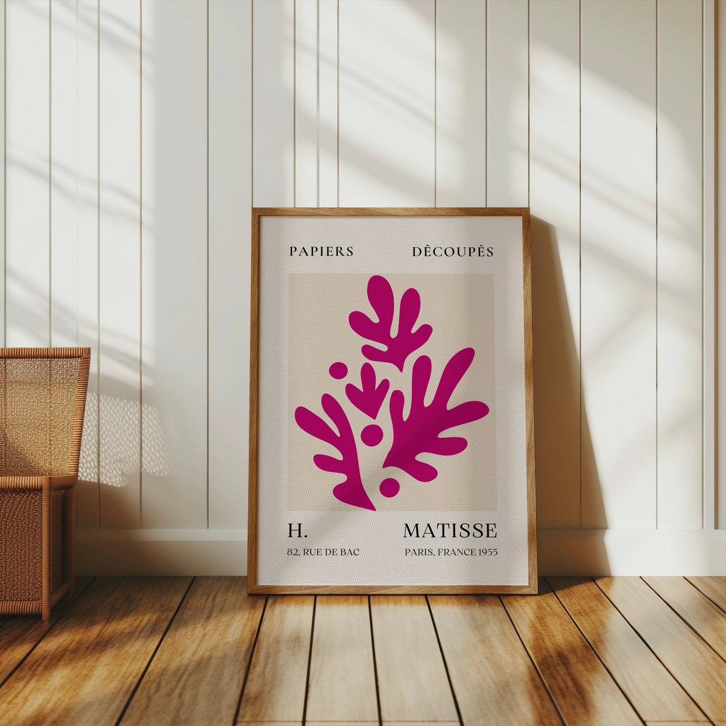 Henri Matisse Paris France 1955 Papiers Découpés poster in a wooden frame leaning against a white paneled wall, styled with warm natural light.
