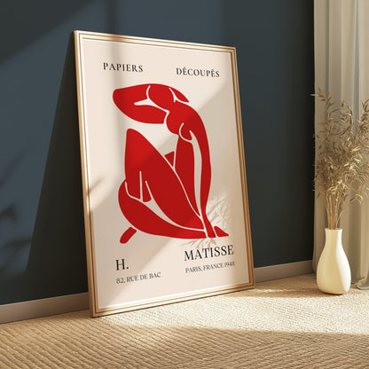 H. Matisse 1948 Papiers Découpés poster in a wooden frame, leaning against a dark wall with minimalist decor, showcasing modern elegance.