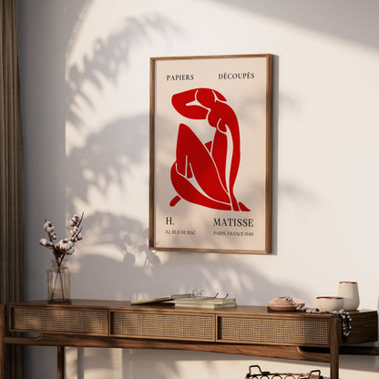 Framed H. Matisse 1948 Papiers Découpés poster displayed on a wooden console table with decorative accents, adding artistic charm to the room.