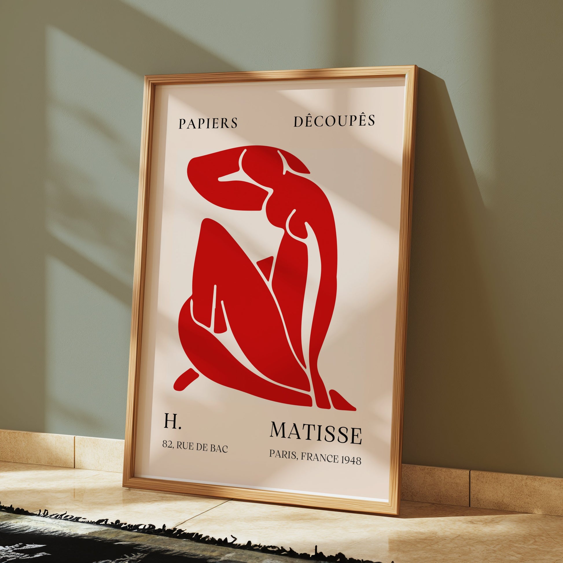 Framed H. Matisse 1948 Papiers Découpés poster placed on a tiled floor against a green wall, blending modern art with minimalist decor.