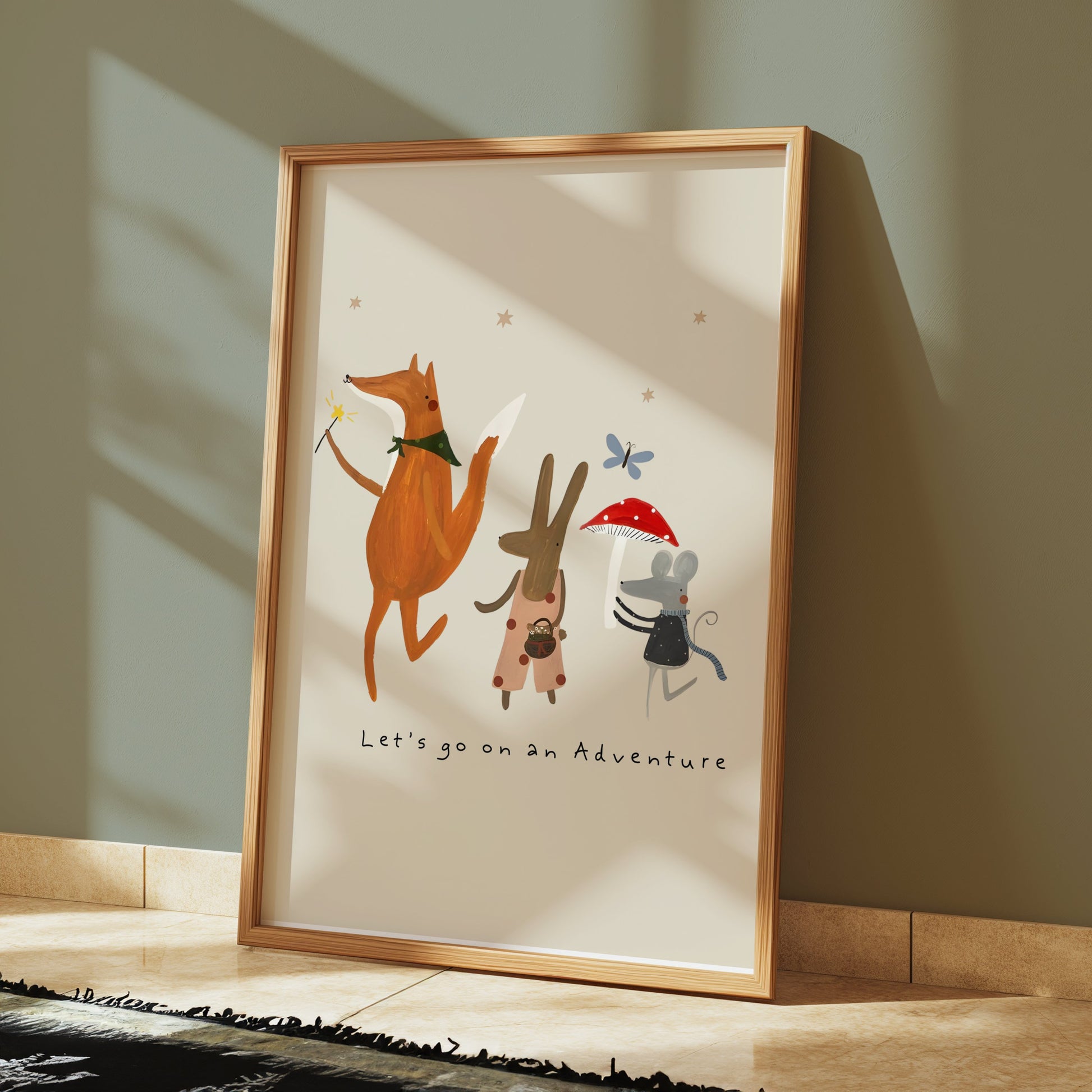 Framed whimsical animal poster with fox, bunny, and mouse characters, leaning against a green wall in a well-lit space.
