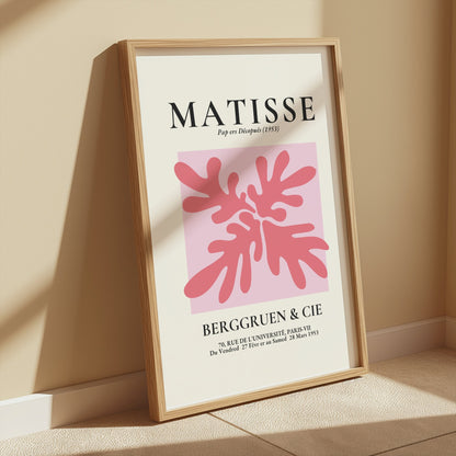Framed Matisse Art Exhibition Paris 1953 poster with abstract pink design, leaning against a wall in a sunlit room.