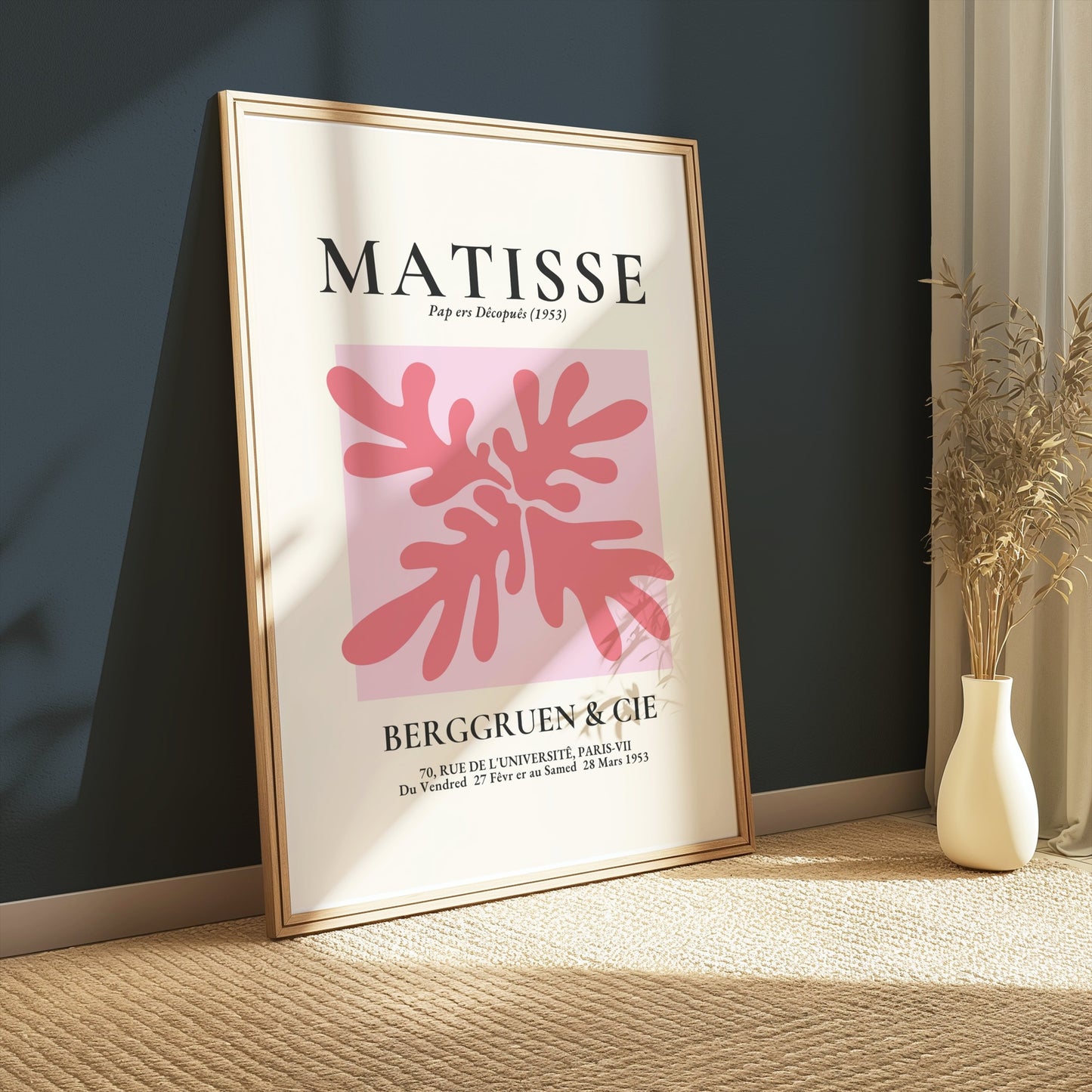 Framed Matisse Art Exhibition Paris 1953 poster with pink abstract design, leaning against a dark green wall on a carpeted floor.