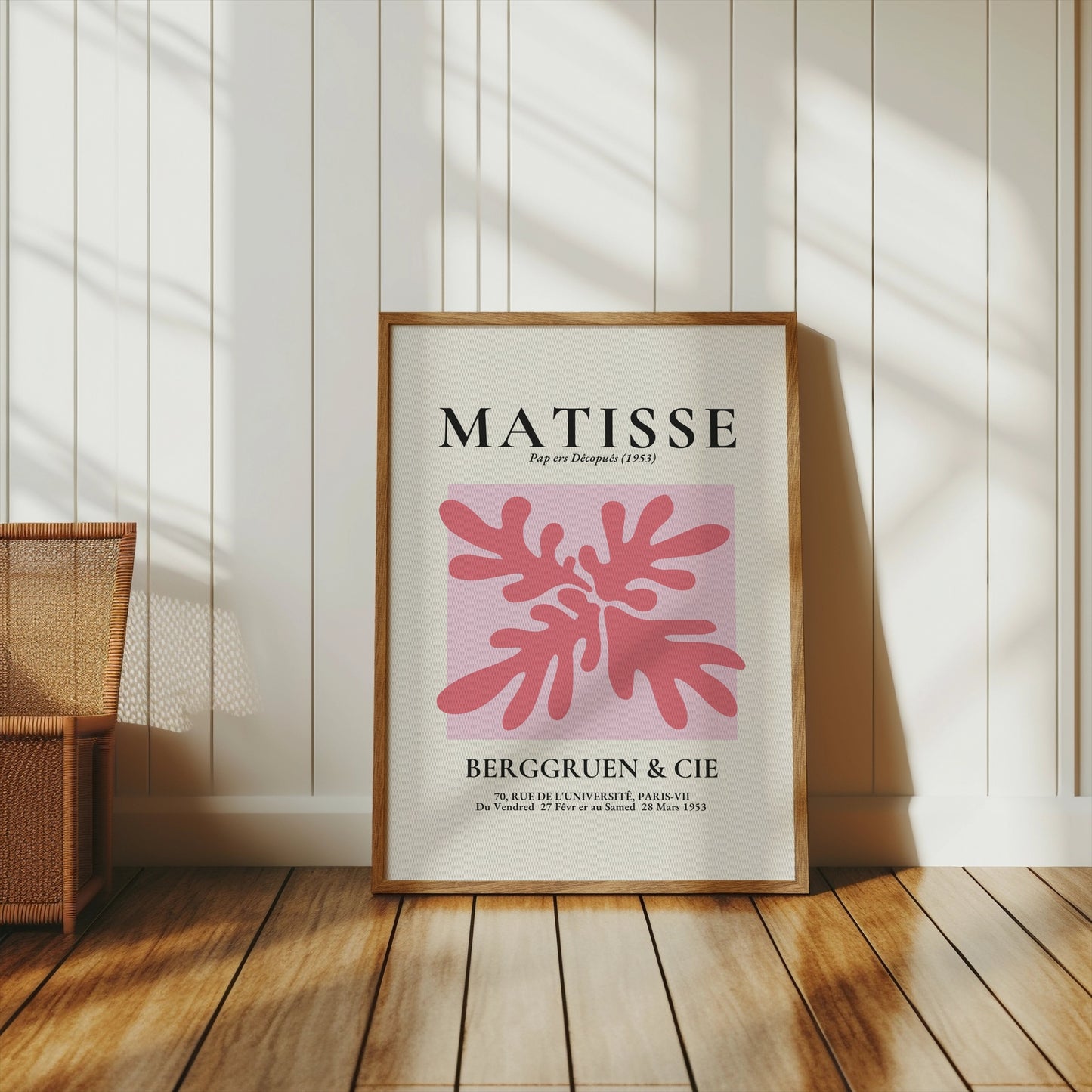 Framed Matisse Art Exhibition Paris 1953 poster with pink abstract design, placed on a wooden floor in a bright room.