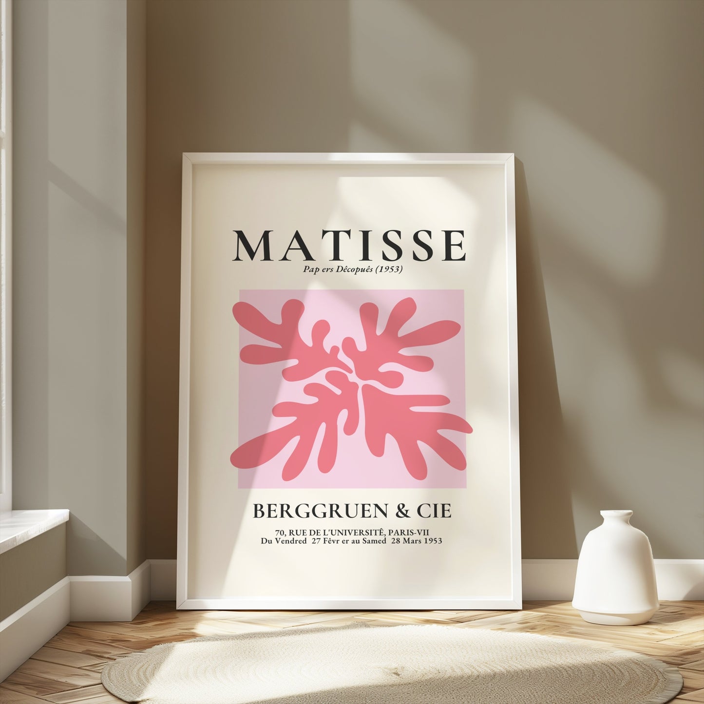 Framed Matisse Art Exhibition Paris 1953 poster with pink abstract design, leaning against a wall in a minimalist interior.