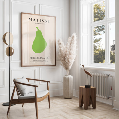 Framed Matisse green pear art print displayed in a bright, modern living room with neutral tones and minimalist decor.