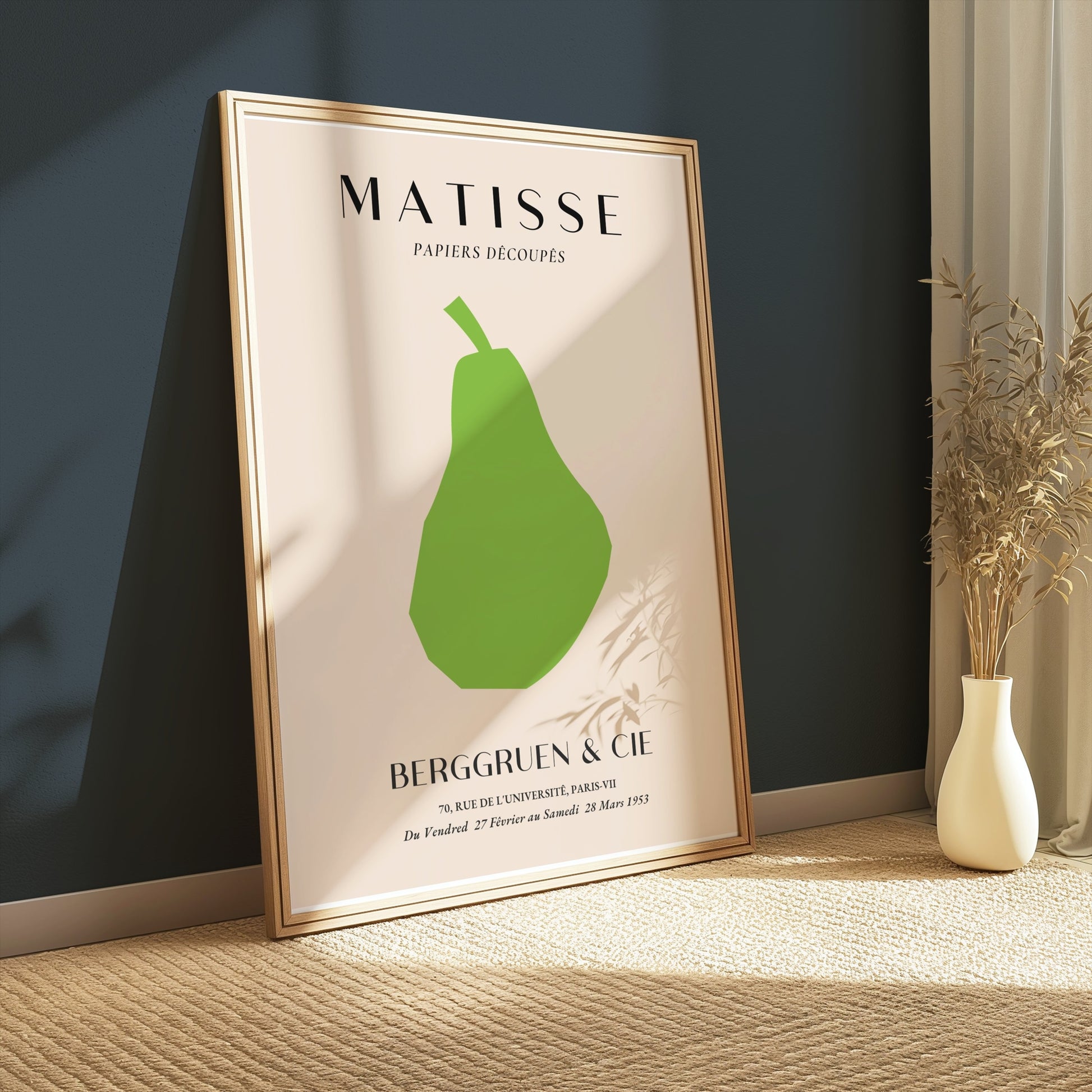 Matisse green pear poster in a wooden frame, propped against a dark teal wall with natural light and minimalist decor.