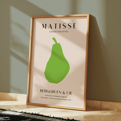 Framed Matisse green pear art print displayed on a tiled floor with sunlight streaming in, ideal for modern interiors.