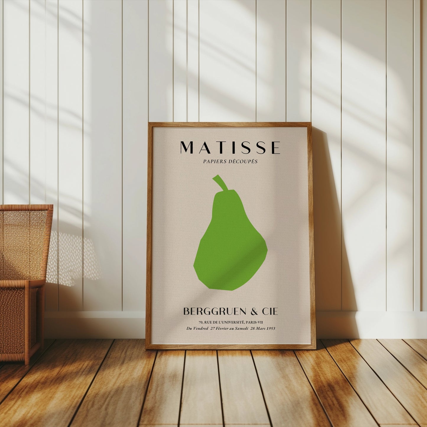 Matisse green pear poster in a wooden frame, styled in a bright room with wooden flooring and neutral decor elements.