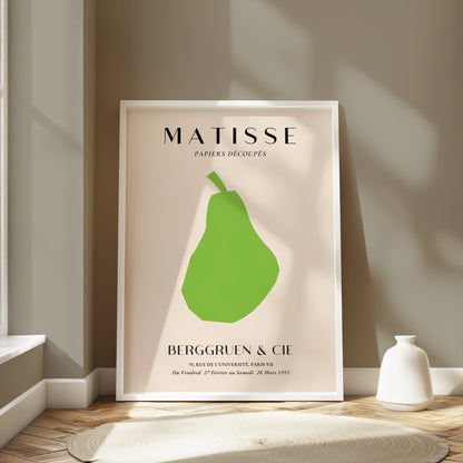 Matisse green pear poster in a white frame, styled in a modern room with soft lighting and neutral decor accents.