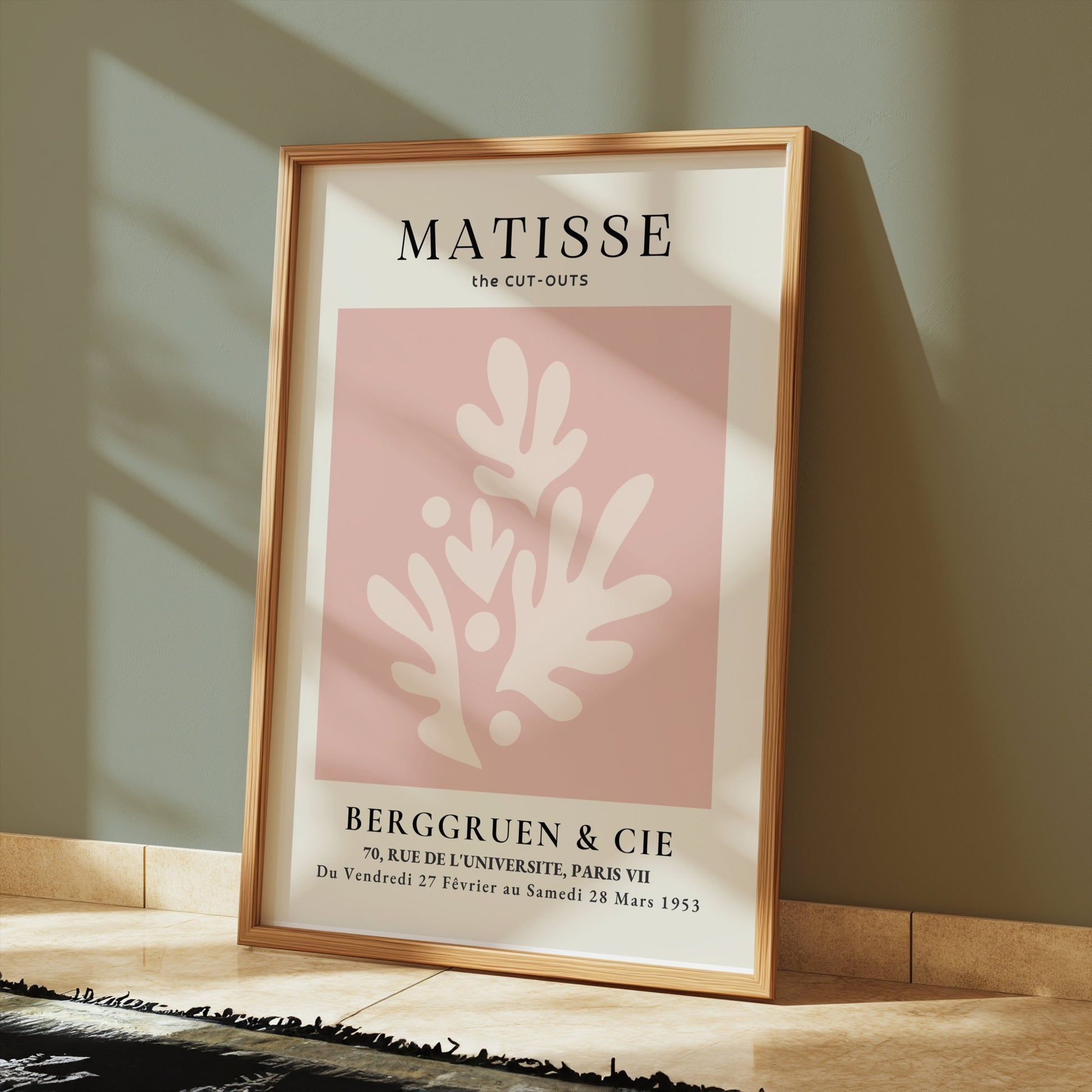 Matisse Cut-Outs Berggruen & Cie Paris VII poster in a wooden frame, placed on a tiled floor with sunlight streaming in.