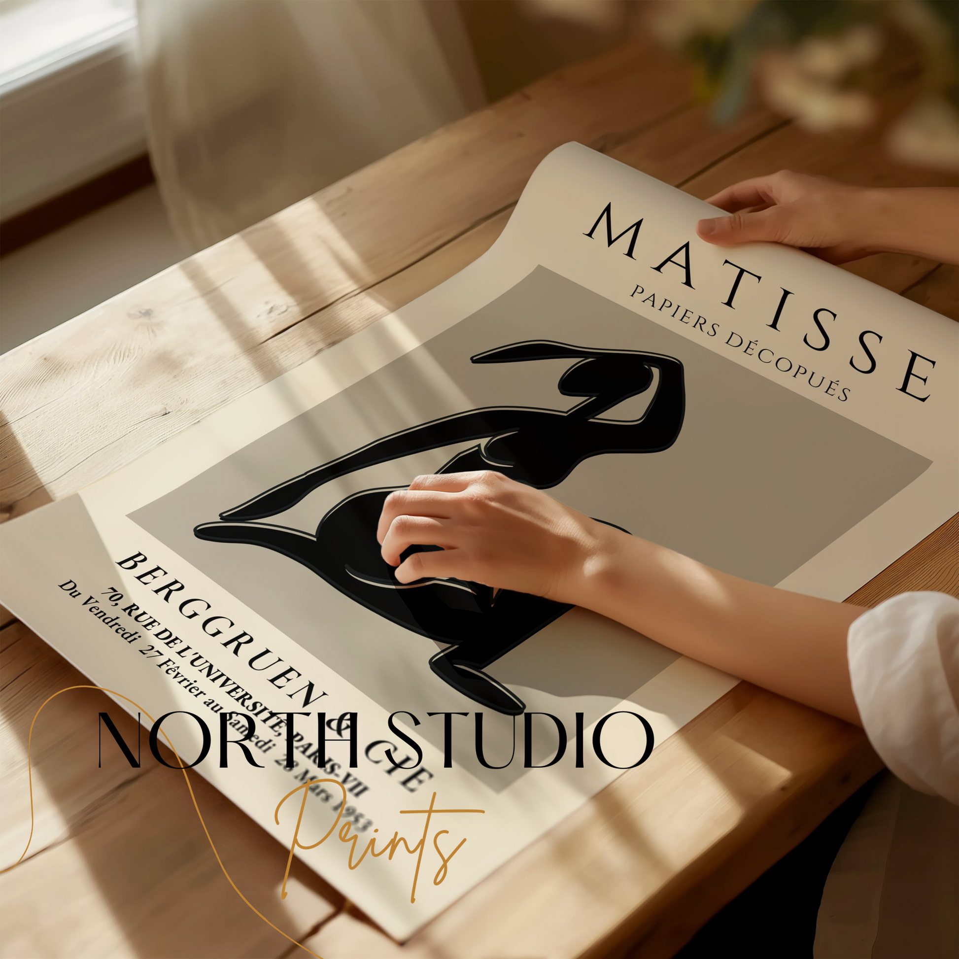 Unframed Matisse Exhibition Papiers Decoupés Berggruen Poster being handled on a wooden table, showcasing its fine art details.