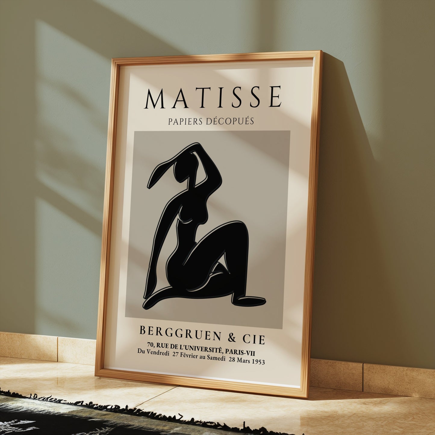 Matisse Exhibition Papiers Decoupés Berggruen Poster leaning against a green wall, framed in light wood for modern art lovers.