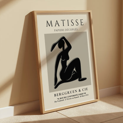 Matisse Exhibition Papiers Decoupés Berggruen Poster leaning on a beige wall, framed in wood, ideal for modern and vintage decor.