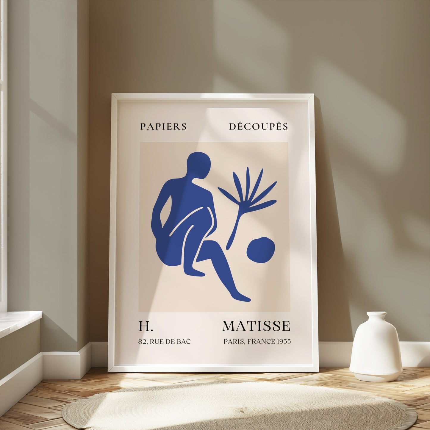 Framed Matisse inspired modern art poster with a blue abstract figure, styled in a minimalist room with beige walls and natural light.