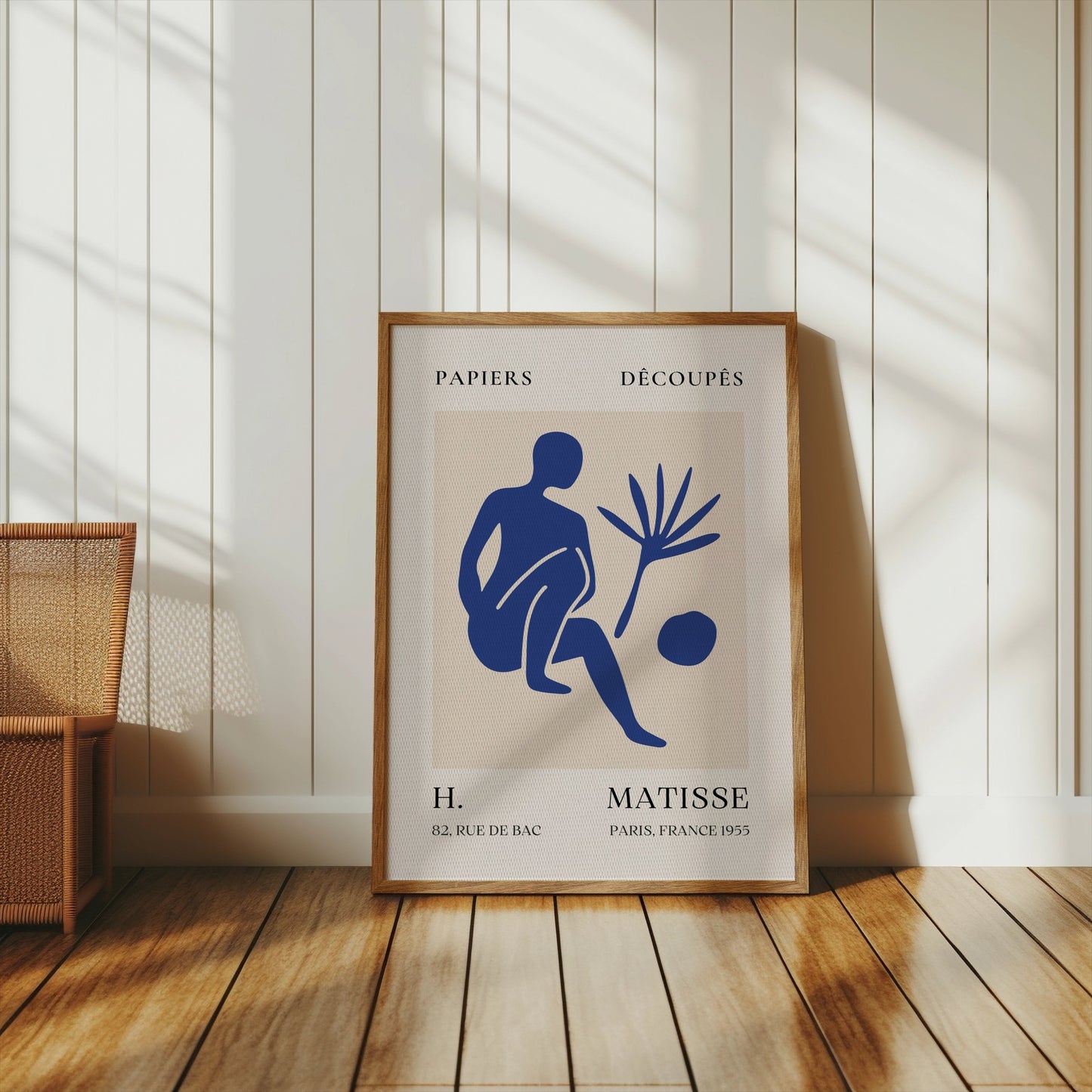 Matisse inspired art poster with a blue abstract figure, framed and styled in a sunlit room with wooden flooring and neutral decor.