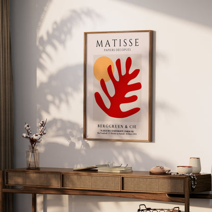 Framed Matisse Art Poster with red coral cut-out and orange sun, styled on a wooden console table with decorative accents in a cozy room.