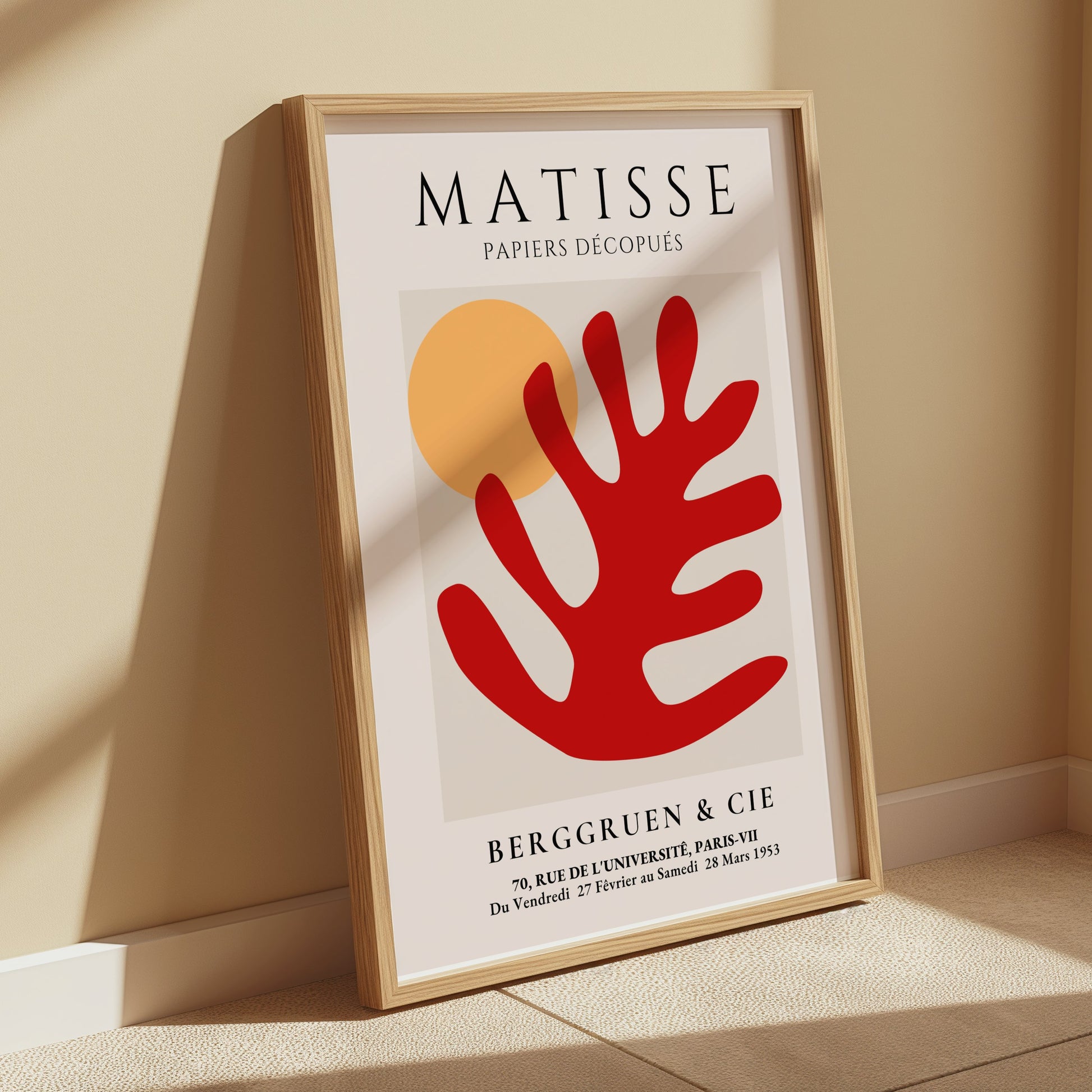 Matisse Art Poster with red coral and orange sun, framed and leaning against a beige wall, styled in a room with warm natural lighting.