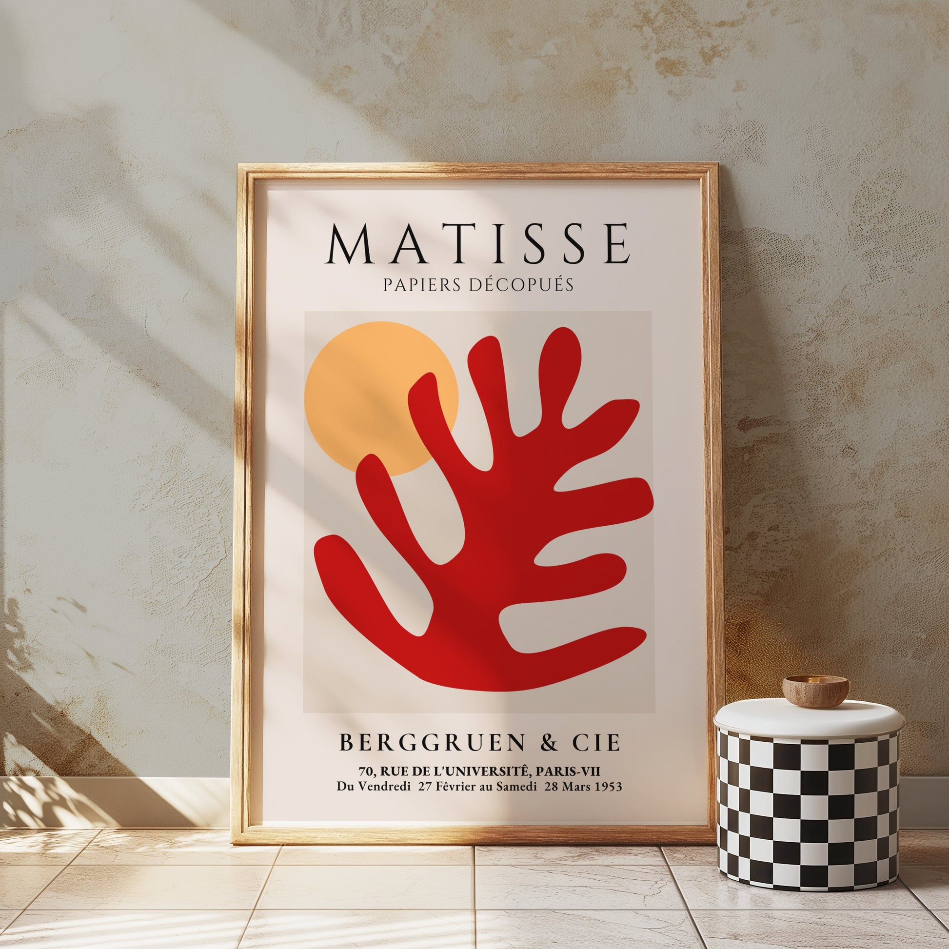 Framed Matisse Art Poster with red coral cut-out and orange sun, styled in a minimalist room with a checkered stool and textured walls.