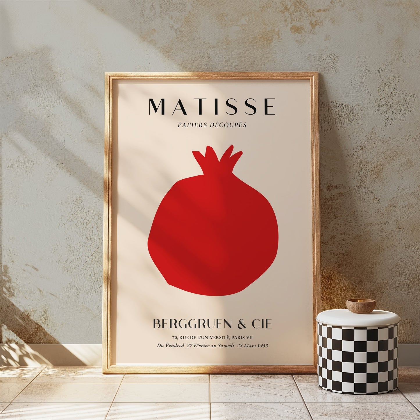 Matisse Papiers Decoupes Berggruen & Cie poster in a gold frame leaning against a textured wall, paired with a decorative checkered jar.