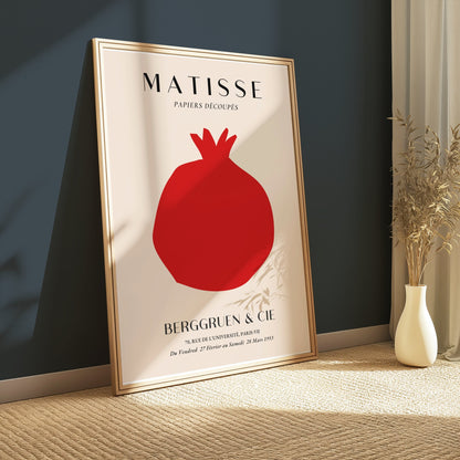Matisse Papiers Decoupes Berggruen & Cie poster in a gold frame leaning against a dark green wall, surrounded by natural light and decor.