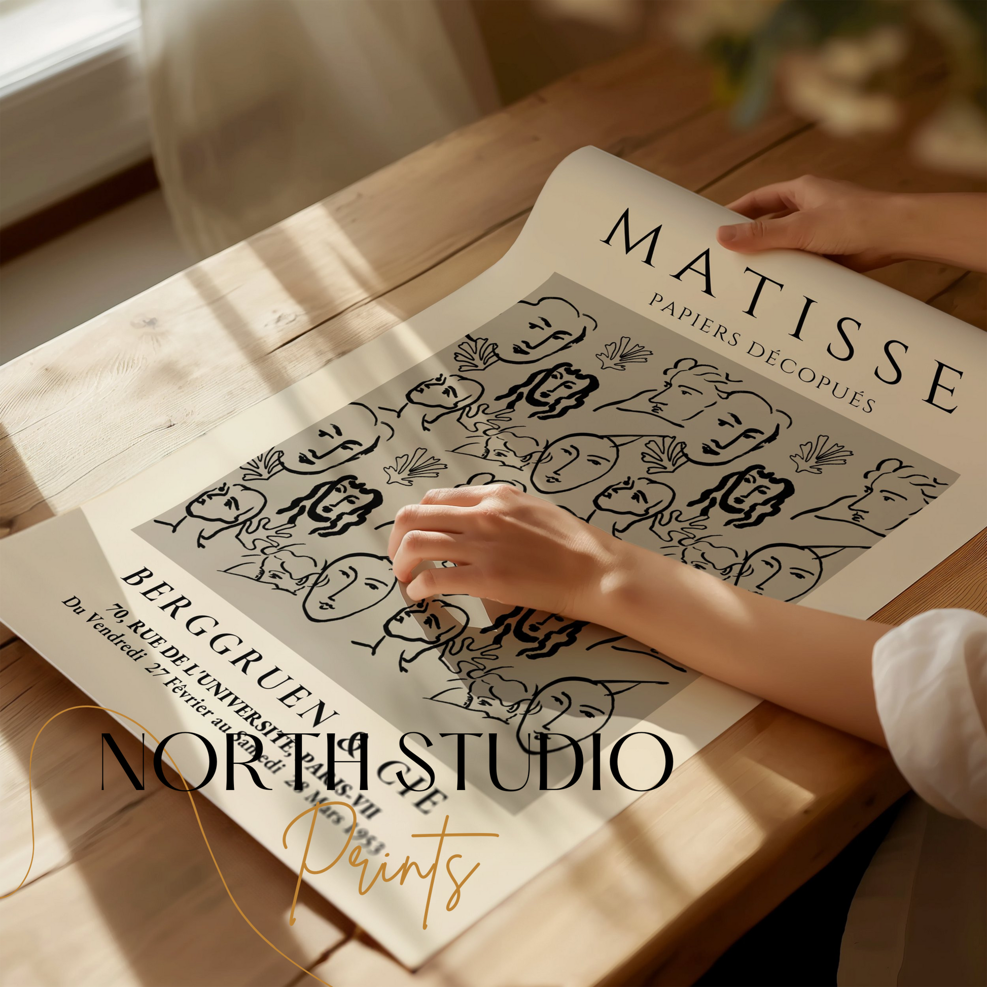Unframed Matisse Papiers Découpés exhibition poster being unrolled on a wooden table, showcasing its abstract design for art enthusiasts.