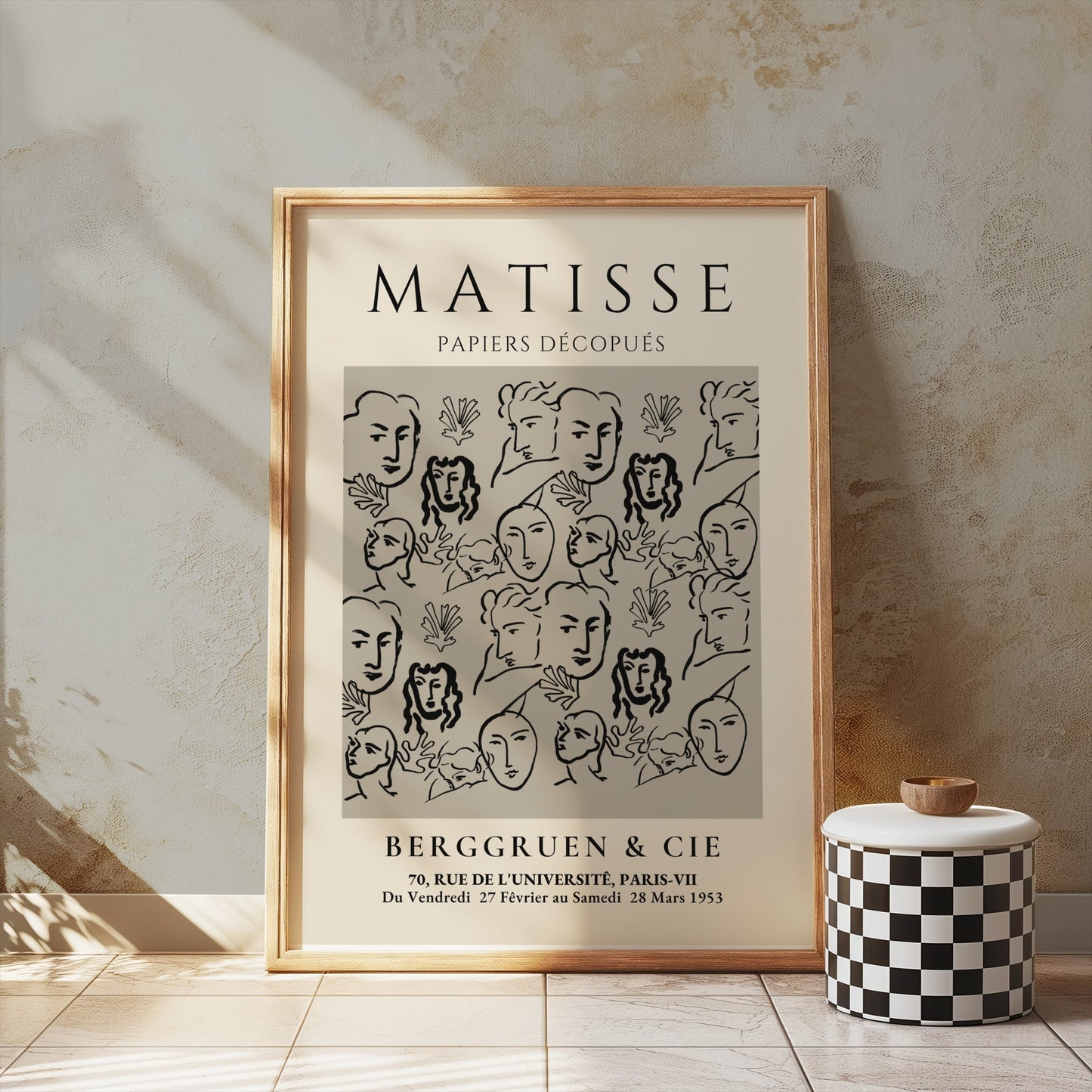 Matisse Papiers Découpés exhibition poster leaning against a textured wall, styled with a checkered decor piece for vintage aesthetics.