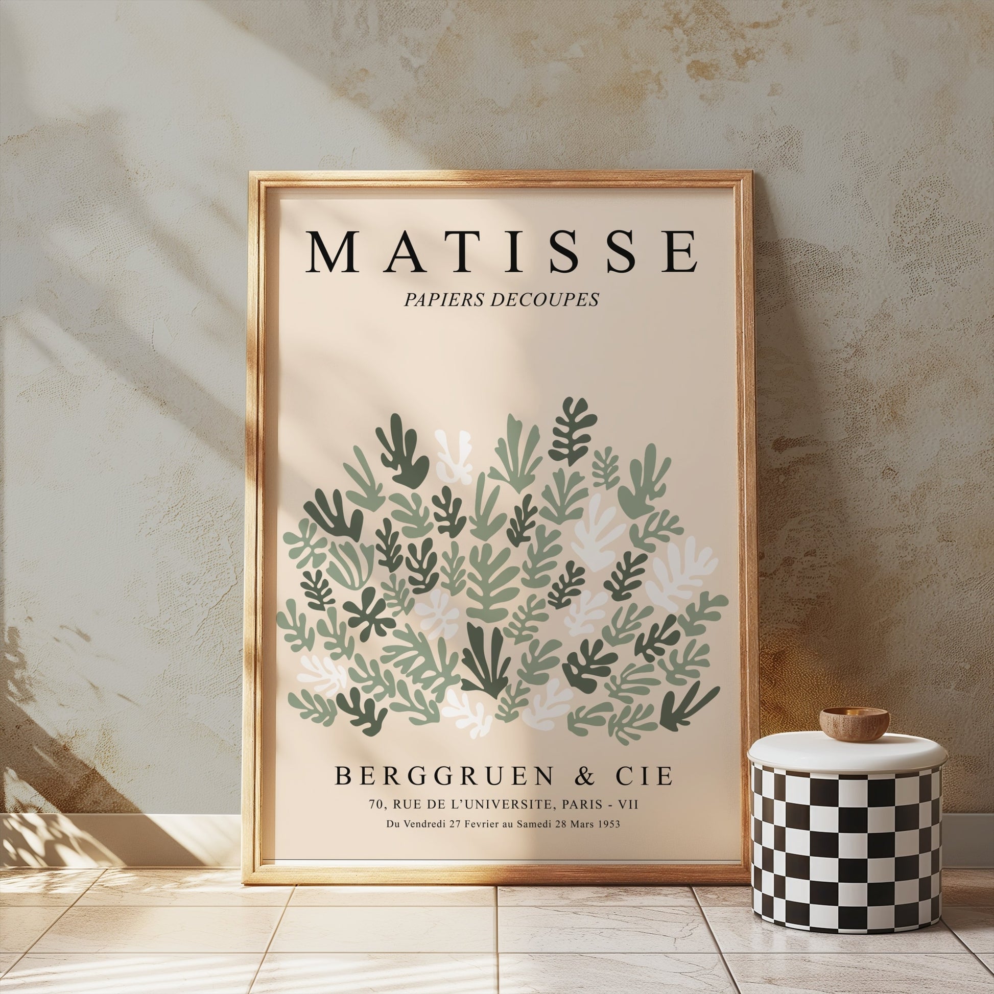Framed Matisse Papiers Decoupes poster with green botanical art, styled on a table against a textured wall for modern home decor.