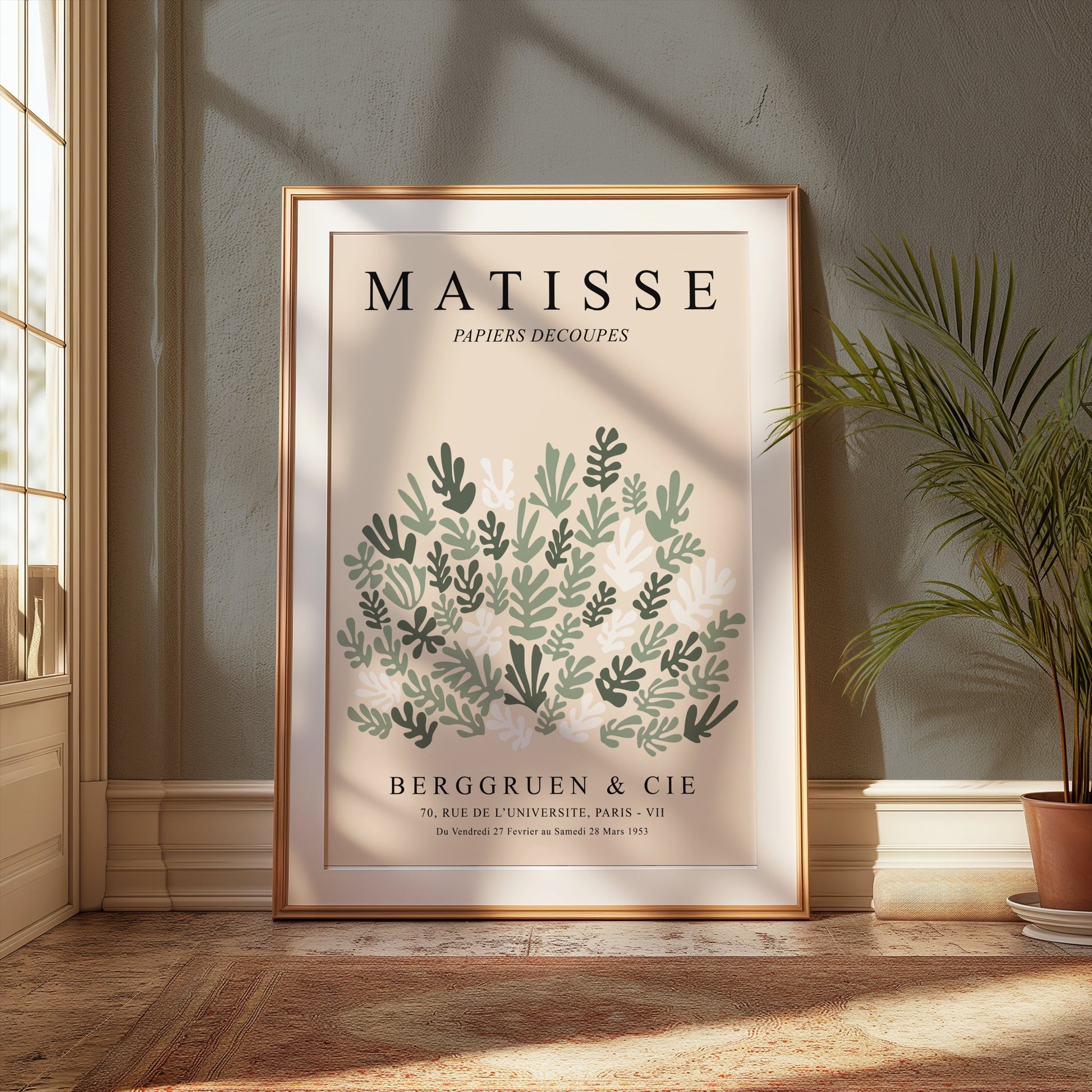 Matisse Papiers Decoupes poster in a gold frame, showcasing green leaf cut paper art, placed in a sunlit room with elegant decor.