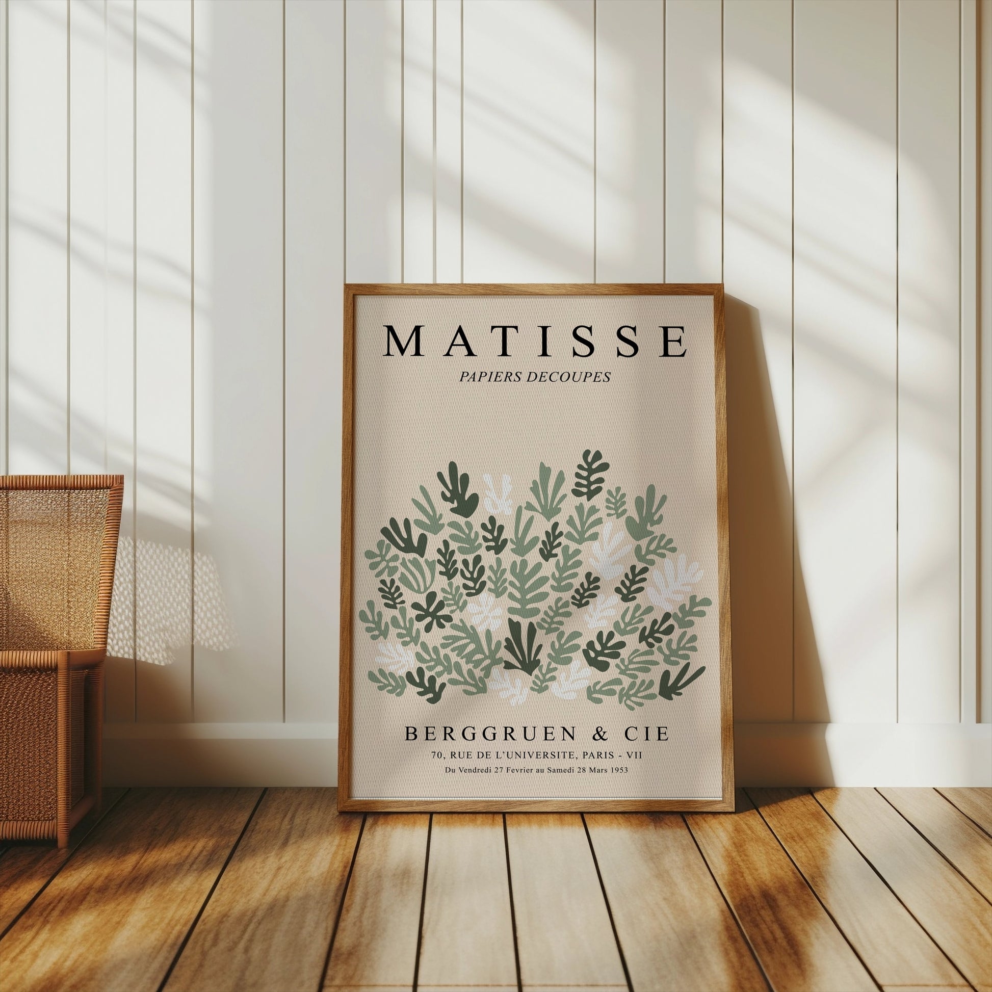Framed Matisse Papiers Decoupes poster with green botanical art, placed on a wooden floor in a bright, minimalist interior.