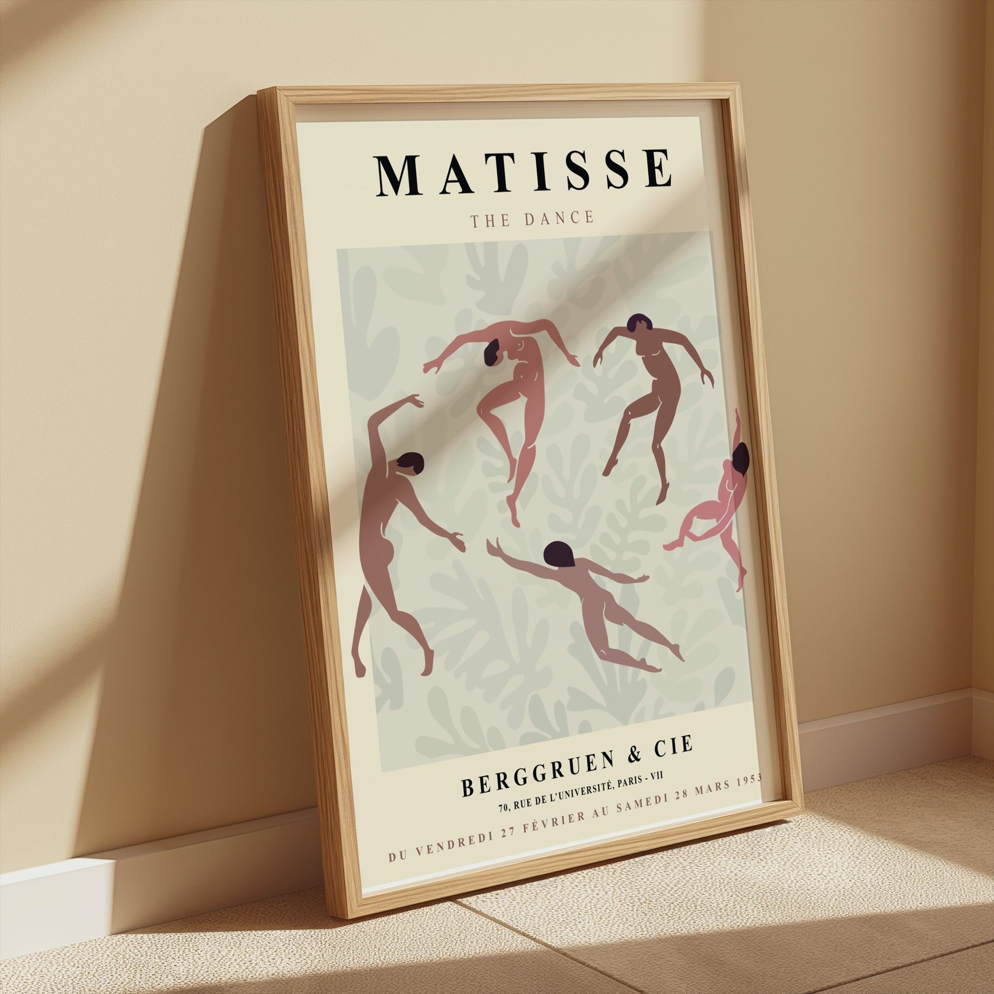 Framed Matisse The Dance exhibition poster leaning against a beige wall with soft sunlight and minimalist decor.