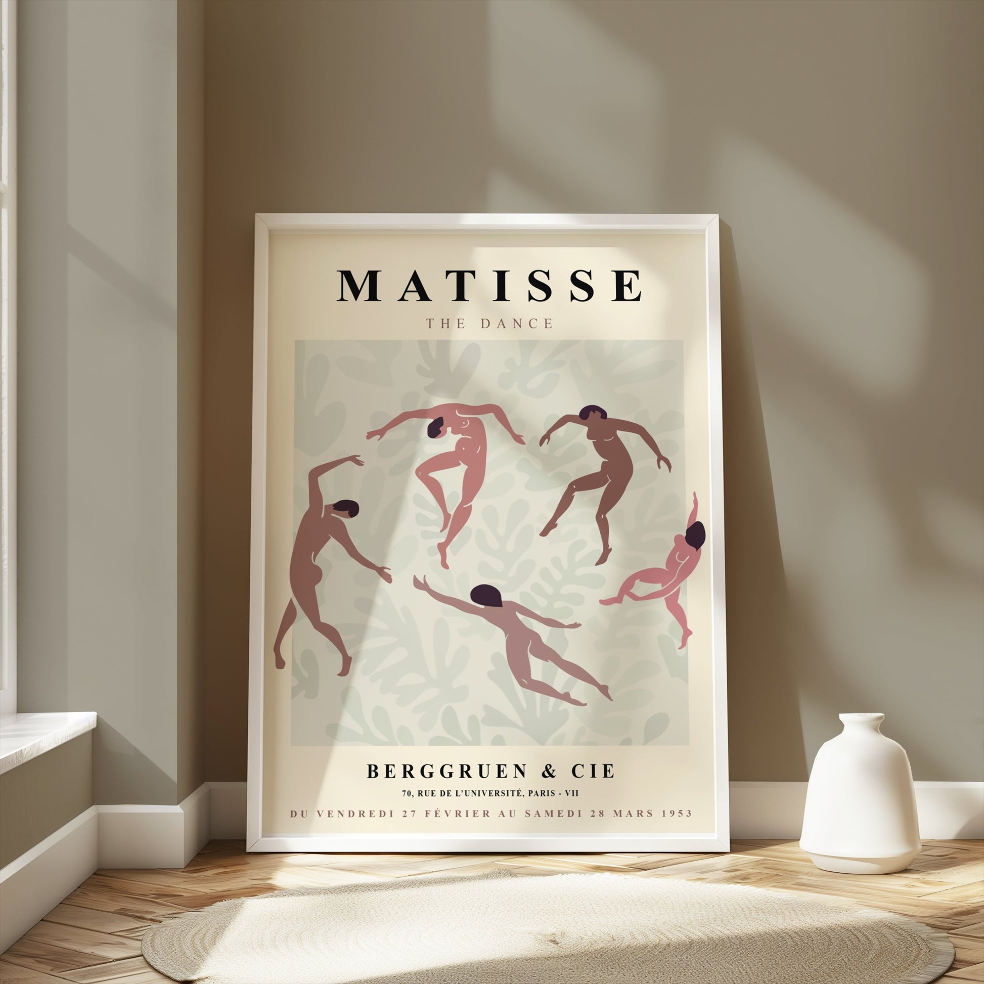 Matisse The Dance exhibition poster in a white frame leaning against a wall in a bright room with natural light and modern decor.