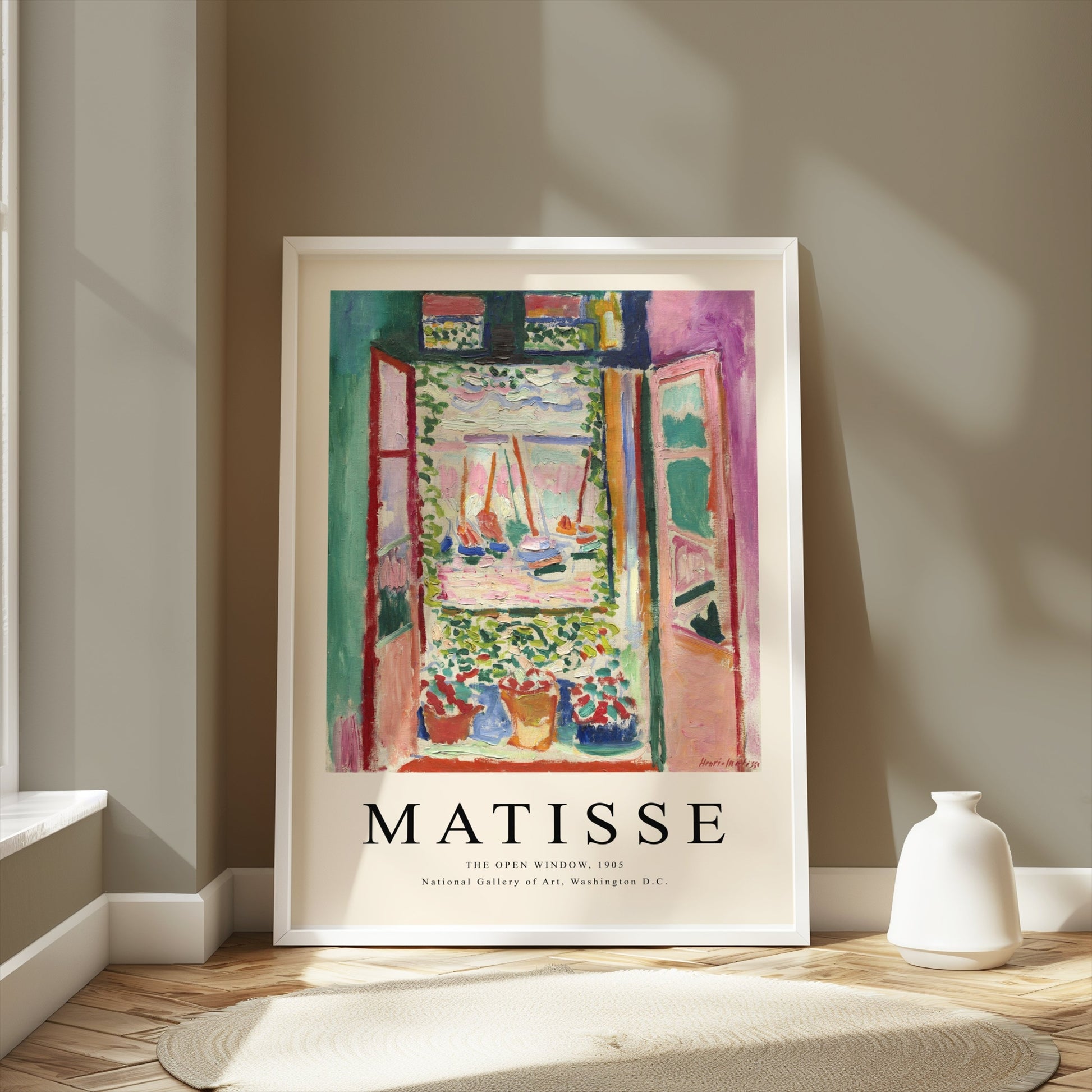 Framed Matisse The Open Window 1905 poster displayed on a wooden floor in a bright room with soft shadows and neutral tones.