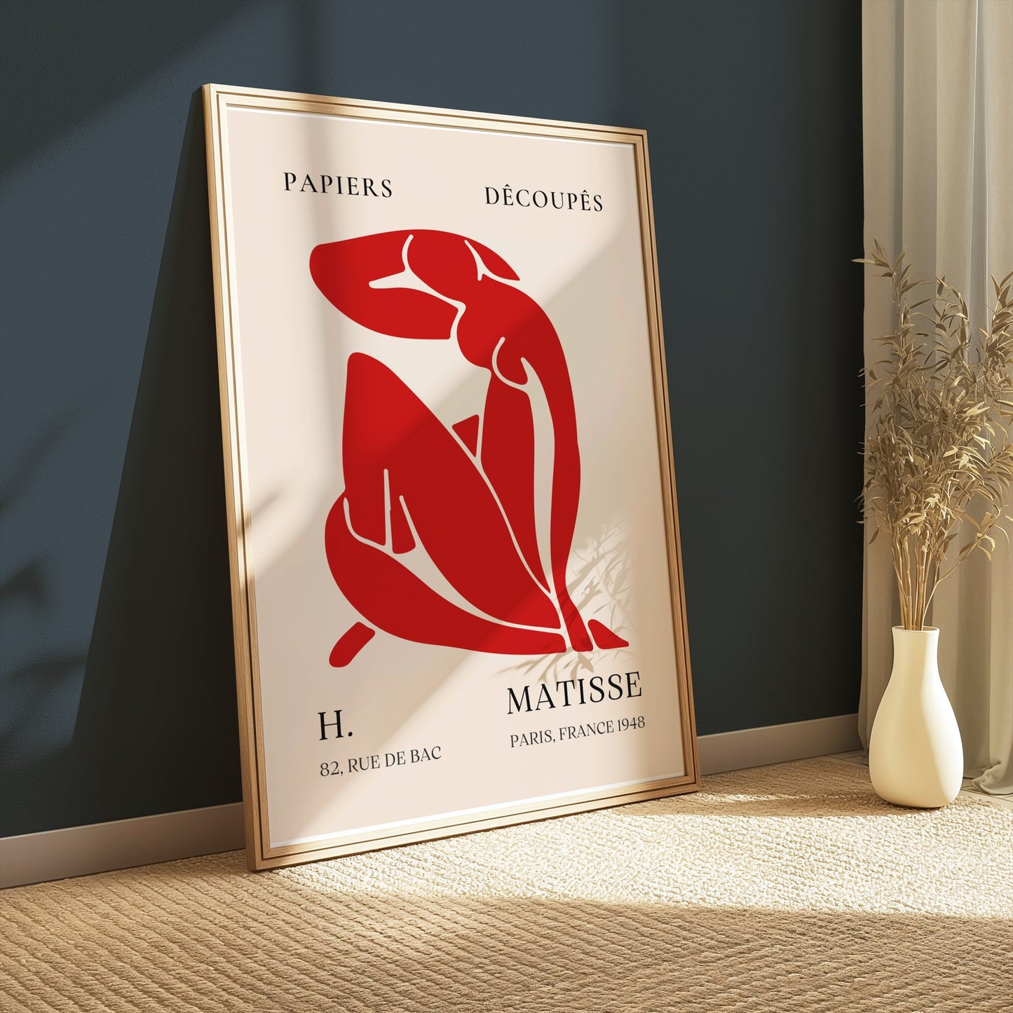 Framed Henri Matisse 'Papiers Découpés' poster with red abstract figure, styled in a cozy corner with natural light and modern decor.