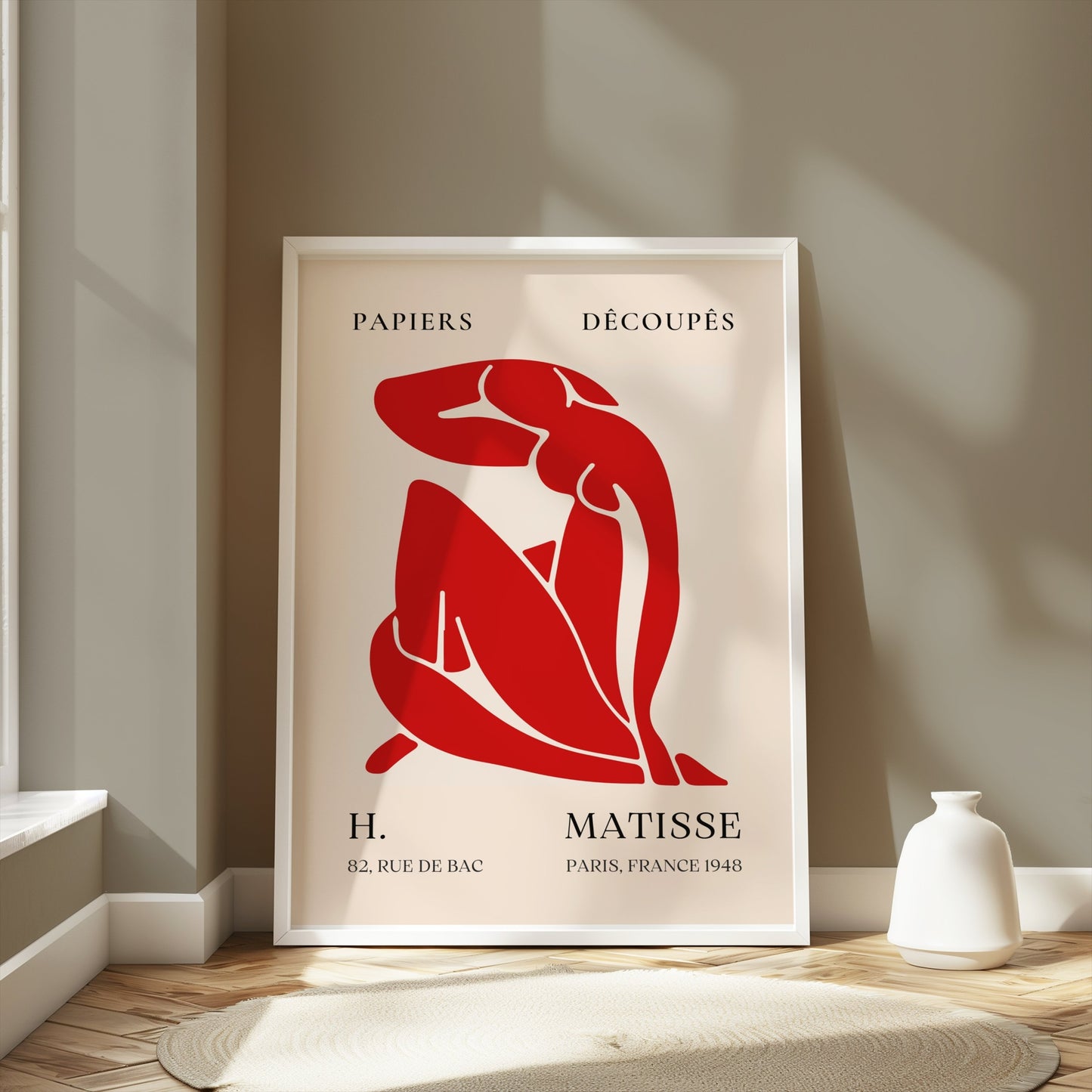 Framed Henri Matisse 'Papiers Découpés' poster with red abstract figure art, styled in a bright room with minimalist decor elements.