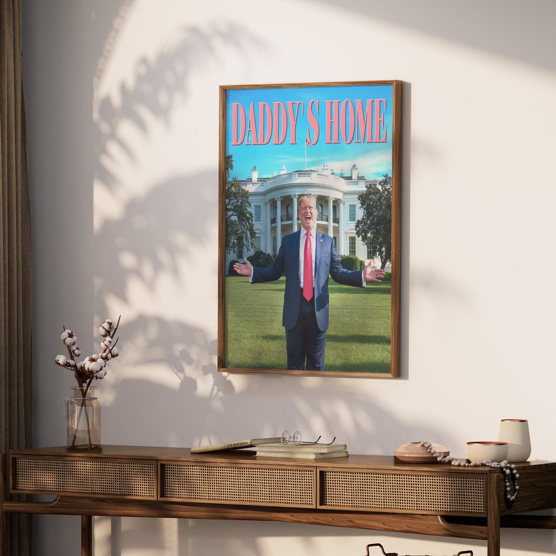 Framed President Donald Trump Daddy's Home poster hung on a wall above a wooden console table, creating a bold statement piece for any room.