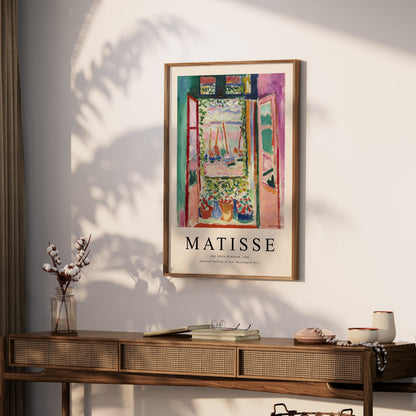 The Open Window by Matisse 1905 framed art print poster hanging above a wooden console table, styled with minimalistic decor elements.