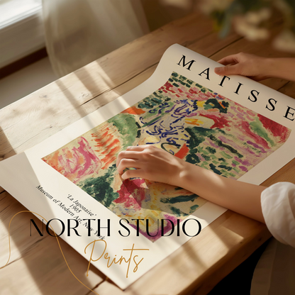 Hands unrolling a Matisse 'La Japonaise' art print on a wooden table, showcasing its vibrant abstract design and artistic details.