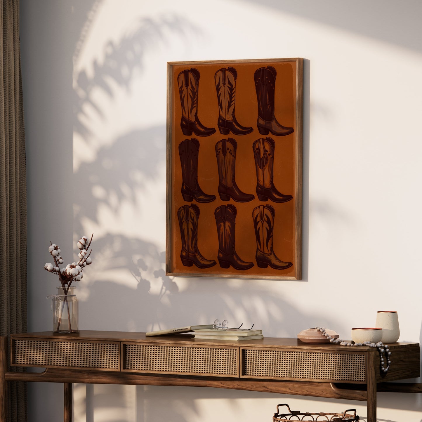 Framed Vintage Cowboy Boots Collection Art Poster hung above a wooden console table with rustic decor and soft natural lighting.
