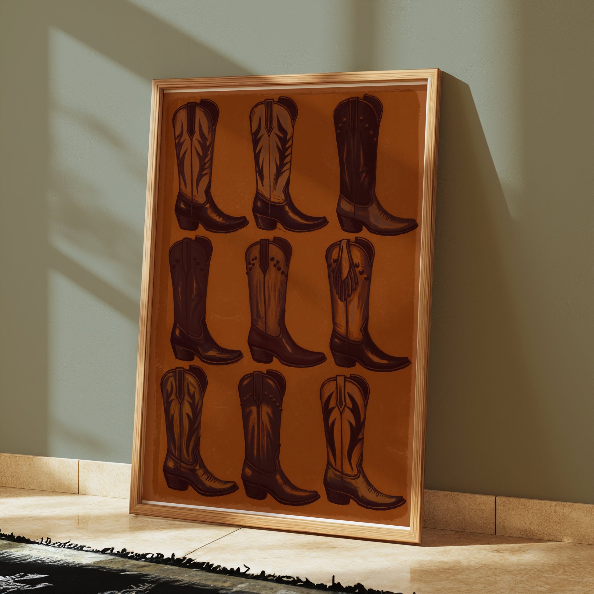 Vintage Cowboy Boots Collection Art Poster in a wooden frame, leaning against a green wall on a tiled floor with sunlight streaming in.