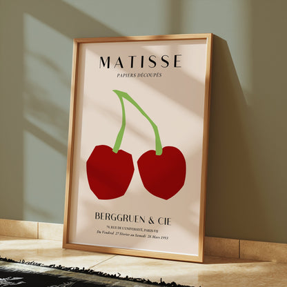 Framed Henri Matisse cherry art print poster placed on a wooden floor, styled with soft lighting and modern minimalist decor.