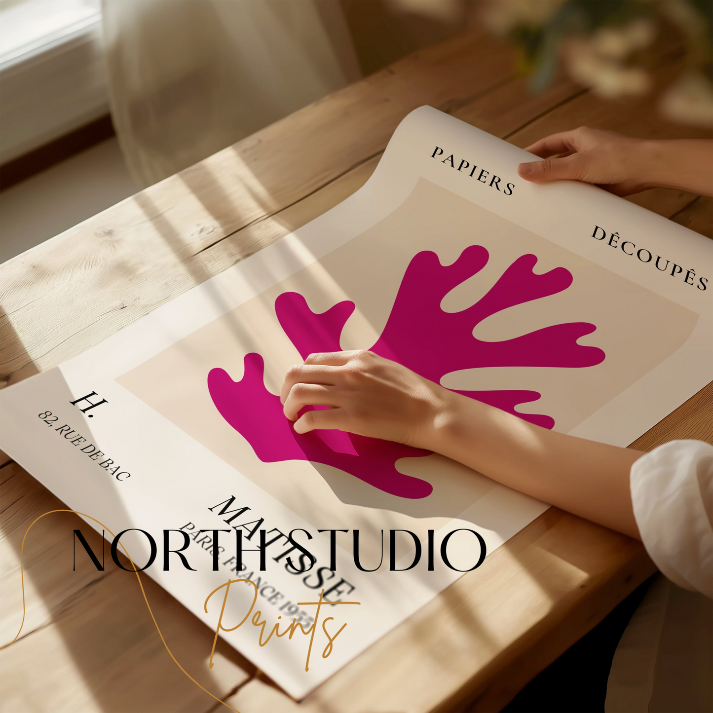 Unframed Vintage Papiers Découpés poster by H Matisse, France 1955, being handled on a wooden table with branding from North Studio Prints.