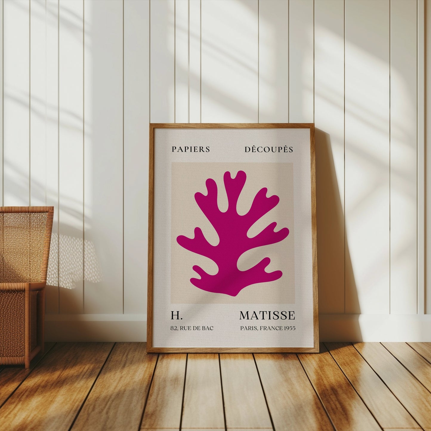 Framed Vintage Papiers Découpés poster by H Matisse, France 1955, leaning against a white paneled wall with warm wooden flooring.