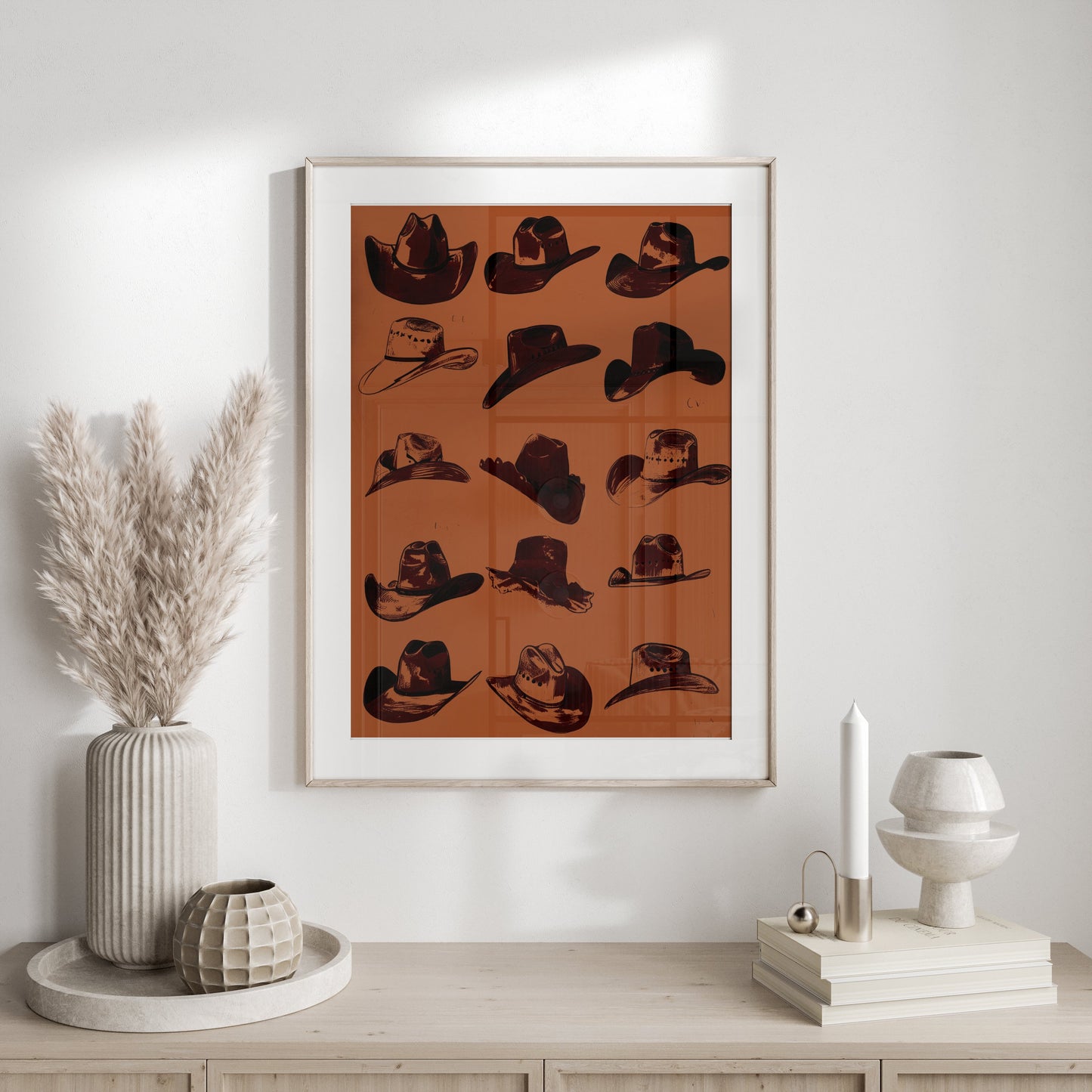 Framed vintage cowboy hats art poster styled on a neutral-toned console table with modern and rustic decor accents.