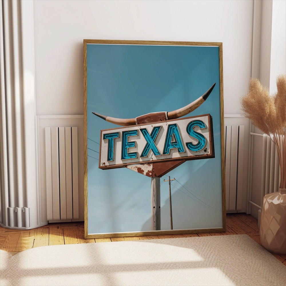 Framed vintage Texas roadside sign art print displayed leaning against a wall in a cozy, sunlit room with wooden flooring.