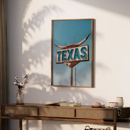 Rustic Texas roadside sign art print in a wooden frame, styled on a console table with decorative accents in a softly lit room.