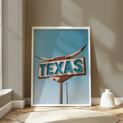 Large framed Texas roadside sign art print leaning against a wall in a sunlit room with minimalist decor and a round rug.