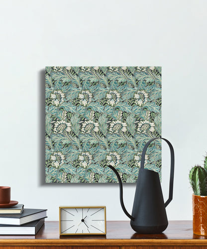 William Morris floral canvas wrap on a desk with books, a clock, and a black watering can, ideal for decorative wall art in workspaces.