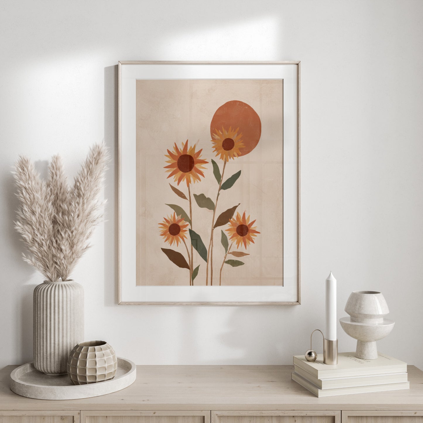 Framed abstract art of sunflowers and a sun against a textured cream background.